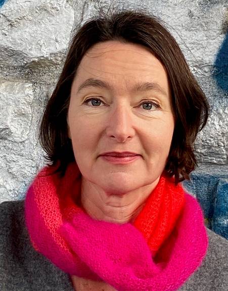 Lucca Müller (Beschreibung: Portrait von Frau mit halb-langen braunen Haaren und rotem Schal.